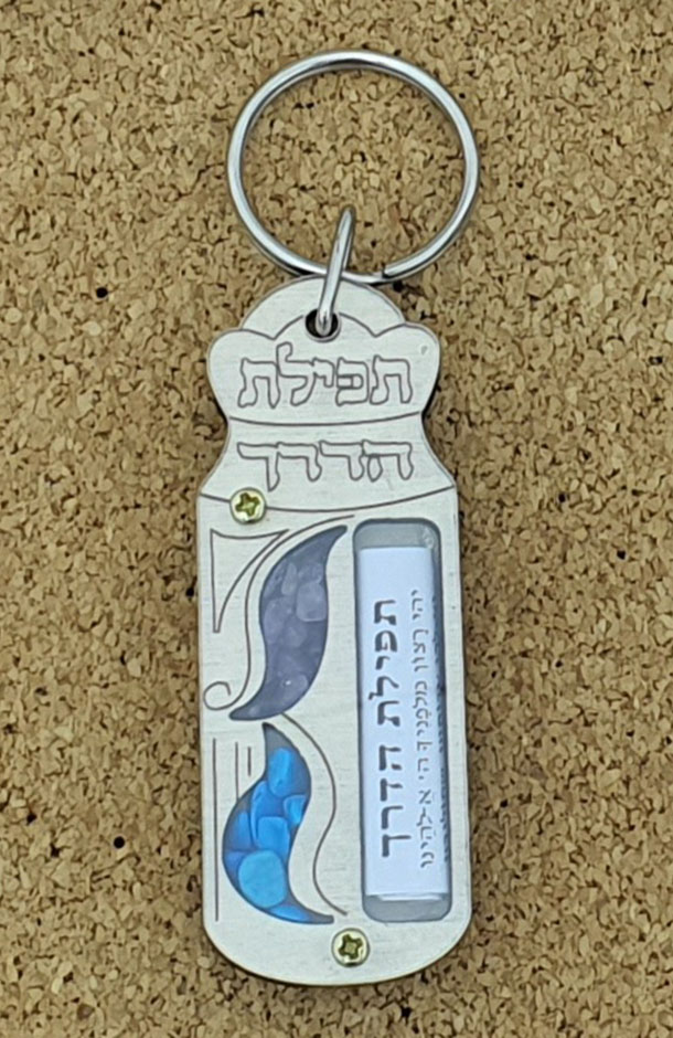 מחזיק מפתחות עשוי עץ בצורת מזוזה עם הכיתוב “תפילת הדרך” בחלק העליון.
מכיל אבנים קטנות מהודרות ותפילת הדרך.
