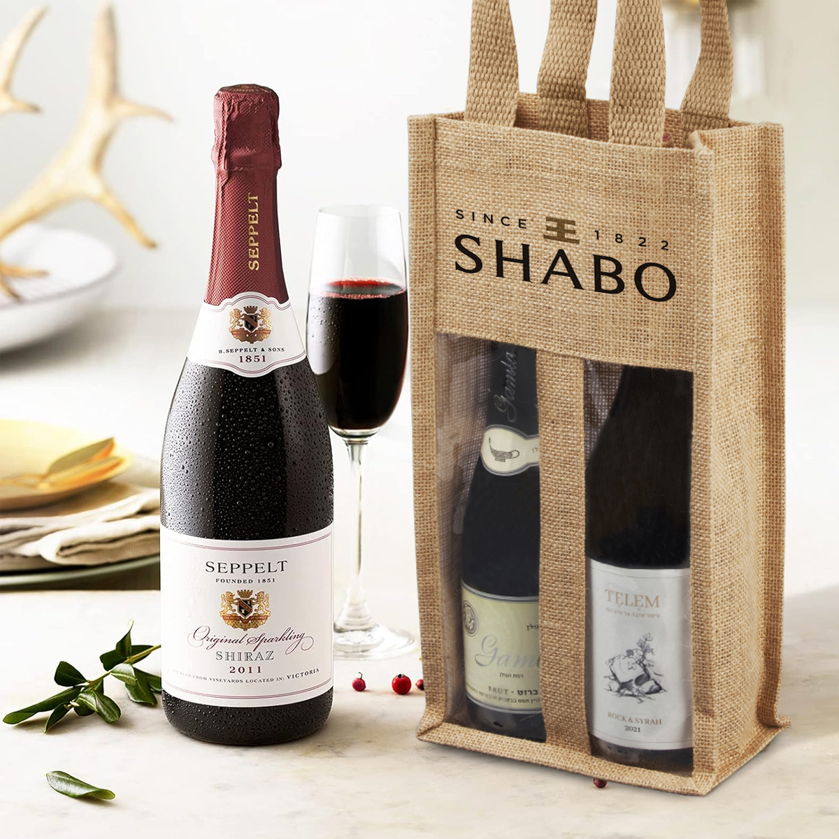 לוטם - תיק יוטה 17x34x9 ס”מ לבקבוקי יין, לנשיאה ביד.
תיק עשוי מסיבי יוטה טבעית. 
חלון PVC  שקוף לתצוגה.
ידיות נשיאה מבד תואם.
ידידותי לסביבה.