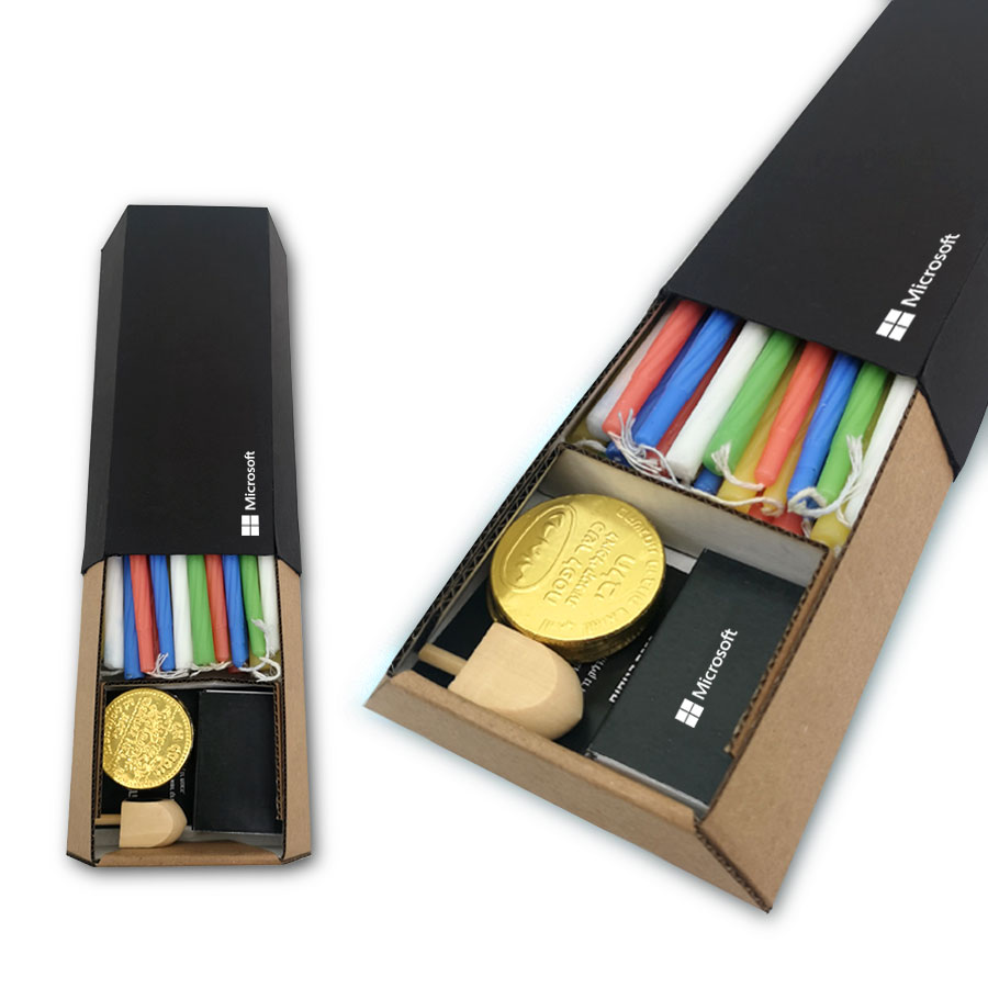 קופסת נרות טרפז 18x10 ס”מ, עשויה קרטון. 
מכילה: 44 נרות עם ברכת הדלקת הנרות, קופסת גפרורים ממותגת צבעוני, סביבון עץ, 4 מטבעות שוקולד.